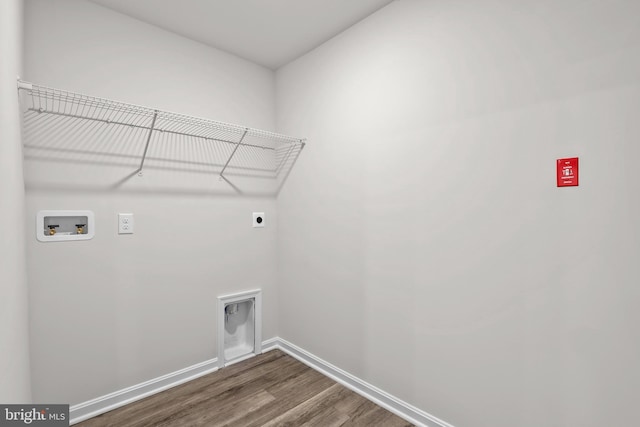 clothes washing area featuring laundry area, baseboards, hookup for an electric dryer, hookup for a washing machine, and dark wood-style flooring