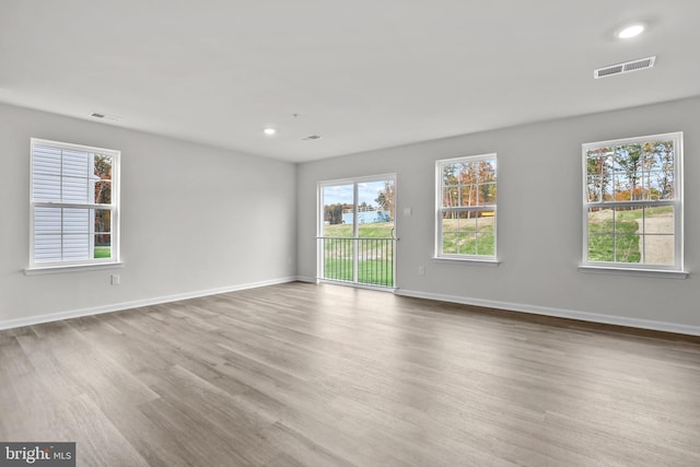 empty room with visible vents, baseboards, and wood finished floors