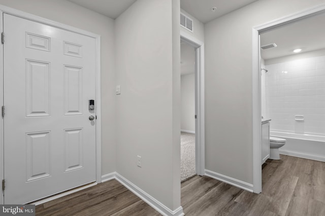 entryway with visible vents, baseboards, and wood finished floors