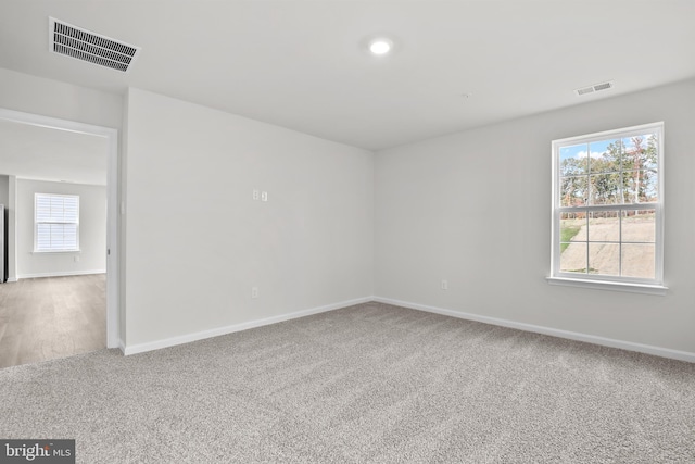 carpeted empty room featuring visible vents and baseboards