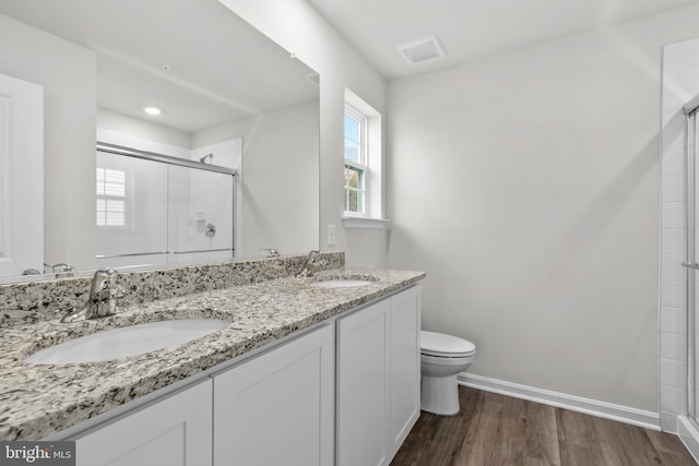 full bathroom featuring a sink, an enclosed shower, baseboards, and toilet