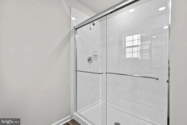 full bathroom featuring a stall shower and baseboards