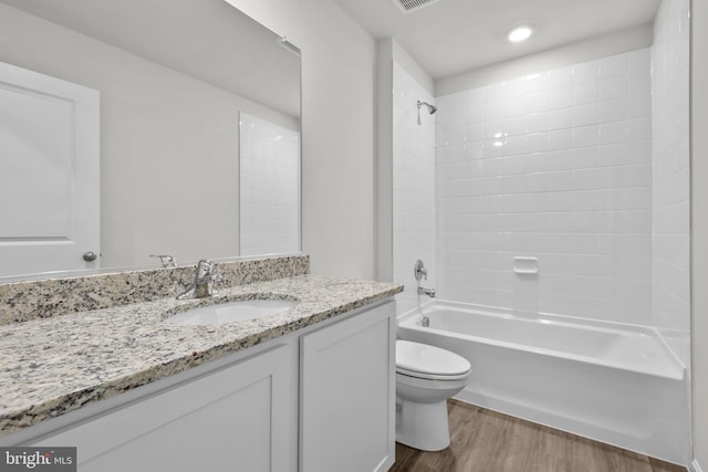 full bath featuring visible vents, toilet, wood finished floors, bathing tub / shower combination, and vanity