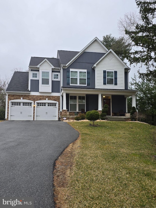 craftsman inspired home featuring central AC unit, driveway, a front lawn, stone siding, and board and batten siding