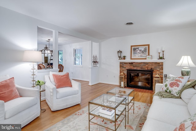 8605 Virginia Ave, Annandale, VA 22003 - living room with a brick fireplace, wood finished floors, and baseboards