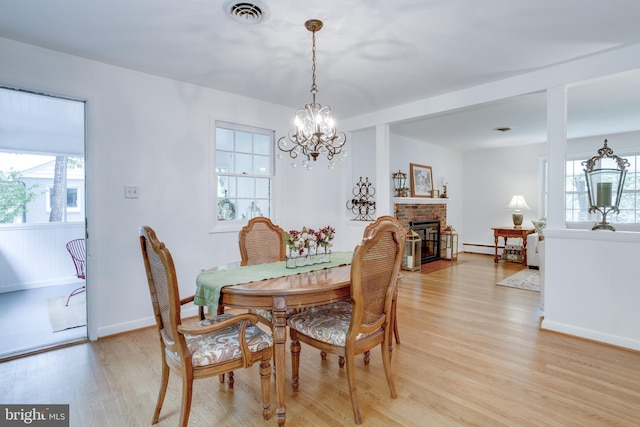 8605 Virginia Ave, Annandale, VA 22003 - dining area featuring light wood finished floors, a chandelier, a fireplace, baseboards, and baseboard heating