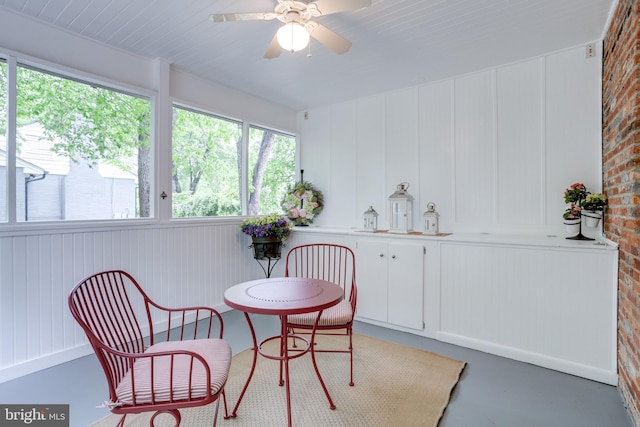 8605 Virginia Ave, Annandale, VA 22003 - dining area featuring a ceiling fan, brick wall, and finished concrete flooring