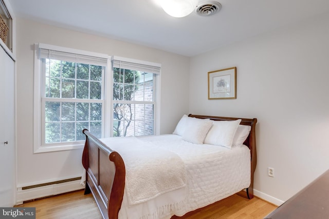 8605 Virginia Ave, Annandale, VA 22003 - bedroom featuring baseboard heating, wood finished floors, baseboards, and a closet