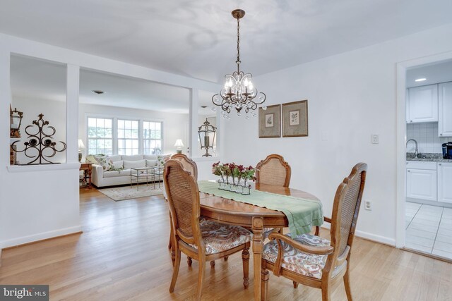 8605 Virginia Ave, Annandale, VA 22003 - dining room featuring light wood-type flooring, a chandelier, and baseboards