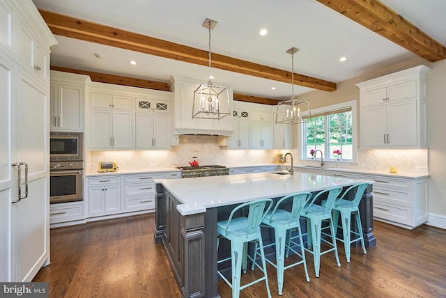 kitchen with white cabinets, stainless steel appliances, light countertops, and a sink