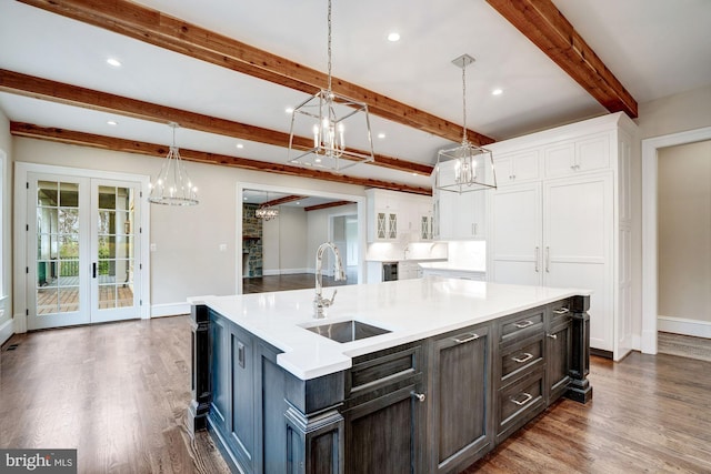 kitchen with a sink, dark wood-style floors, a chandelier, and white cabinets