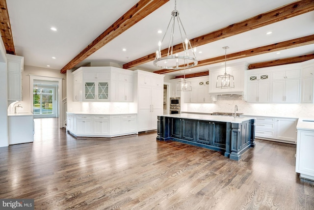 kitchen featuring white cabinetry, a large island, blue cabinets, and light countertops