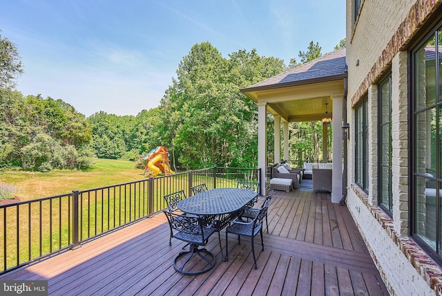 wooden terrace featuring outdoor lounge area, a playground, a yard, and outdoor dining space