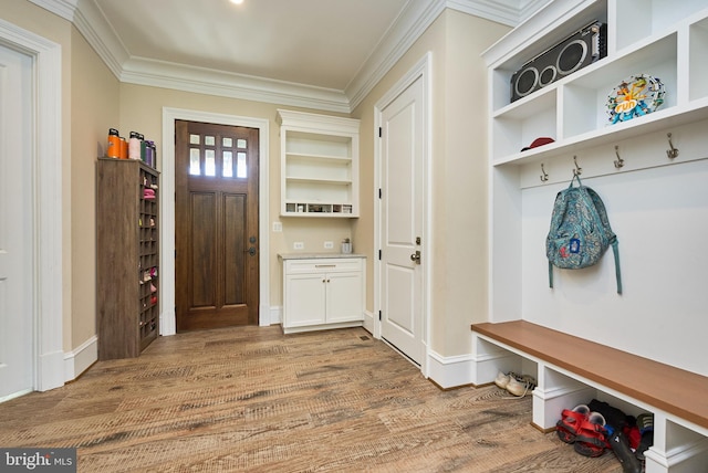 mudroom featuring crown molding, wood finished floors, and baseboards