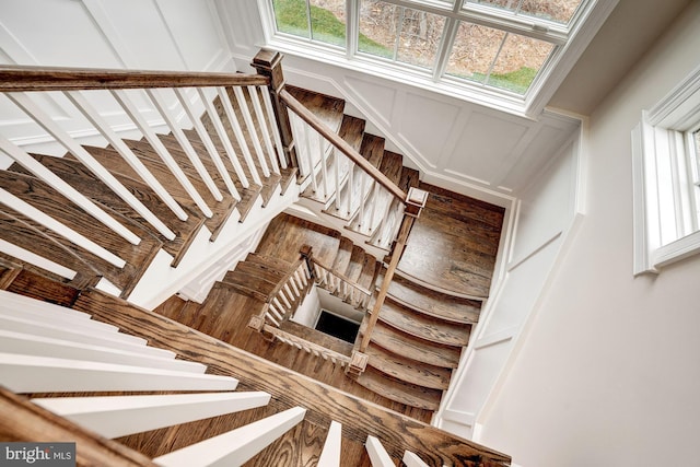 stairs featuring a healthy amount of sunlight and a decorative wall