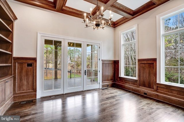 doorway featuring an inviting chandelier, wood finished floors, a wainscoted wall, and coffered ceiling