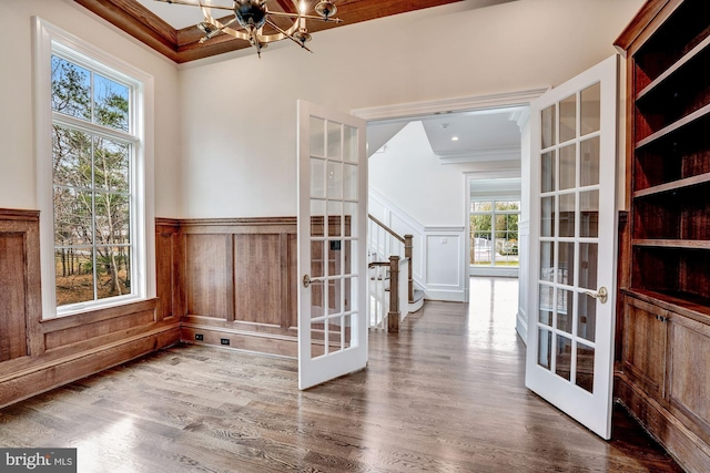 interior space featuring a chandelier, stairs, ornamental molding, french doors, and wood finished floors