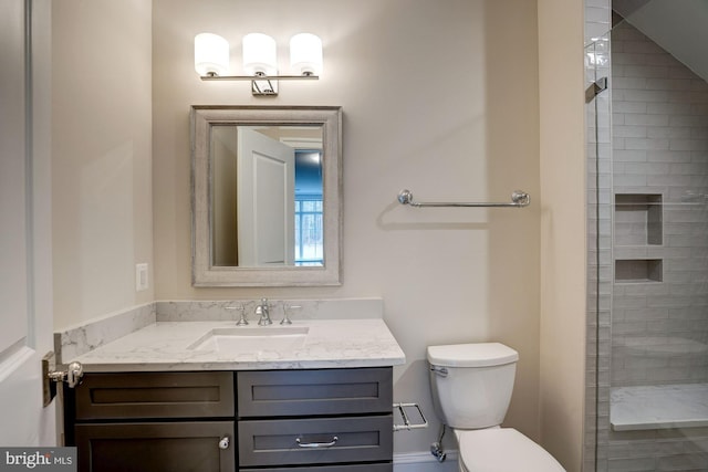 full bath featuring vanity, toilet, and a tile shower