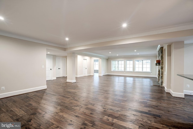 unfurnished living room featuring recessed lighting, dark wood-type flooring, baseboards, and ornamental molding