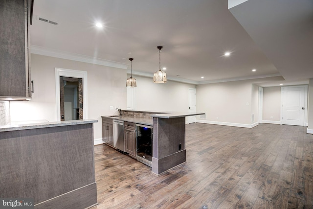 kitchen featuring beverage cooler, visible vents, dark wood-style flooring, stainless steel dishwasher, and crown molding