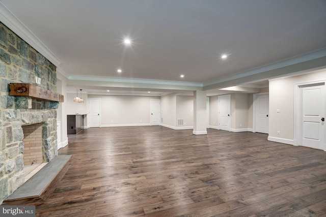 unfurnished living room featuring crown molding, dark wood-type flooring, baseboards, recessed lighting, and a fireplace