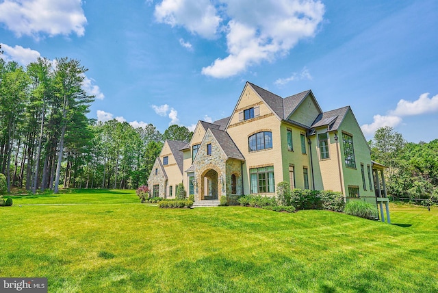 view of front of home with a front yard and stone siding