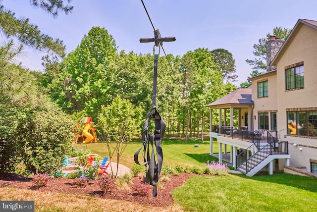 view of yard with stairs, a deck, and a playground