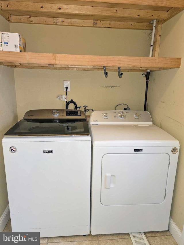 laundry area featuring baseboards, independent washer and dryer, and laundry area