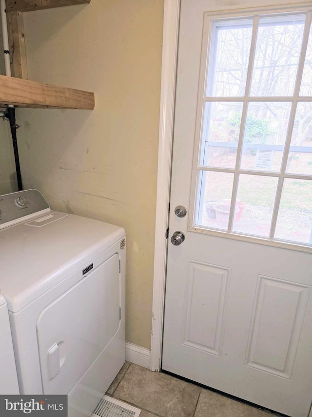 washroom with light tile patterned floors, laundry area, and washing machine and dryer