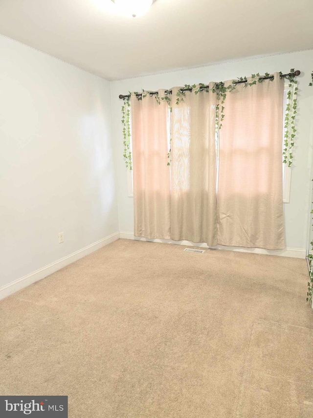 carpeted spare room with baseboards