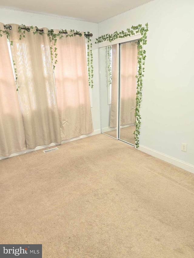 unfurnished room with baseboards and carpet flooring