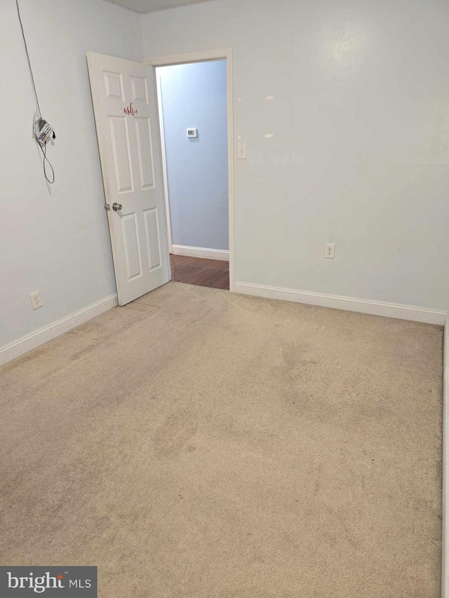 carpeted empty room with baseboards