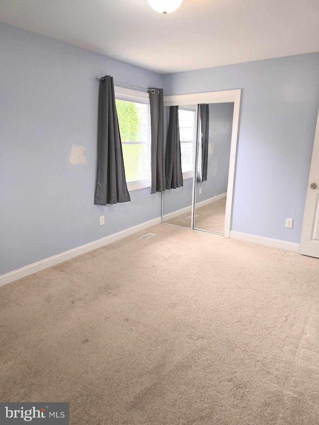 unfurnished bedroom featuring a closet, baseboards, and carpet