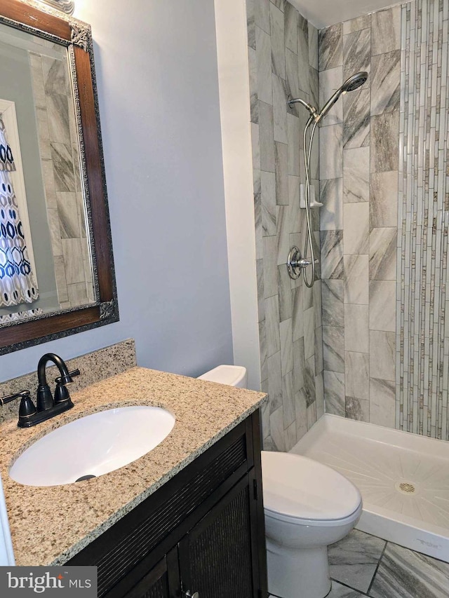 full bath with vanity, toilet, marble finish floor, and a shower stall