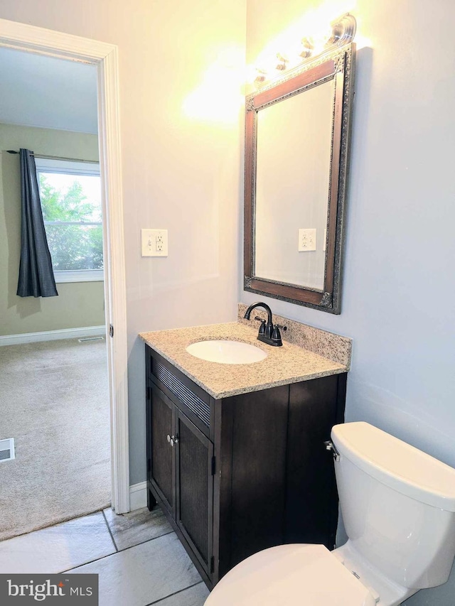 bathroom with visible vents, toilet, vanity, and baseboards