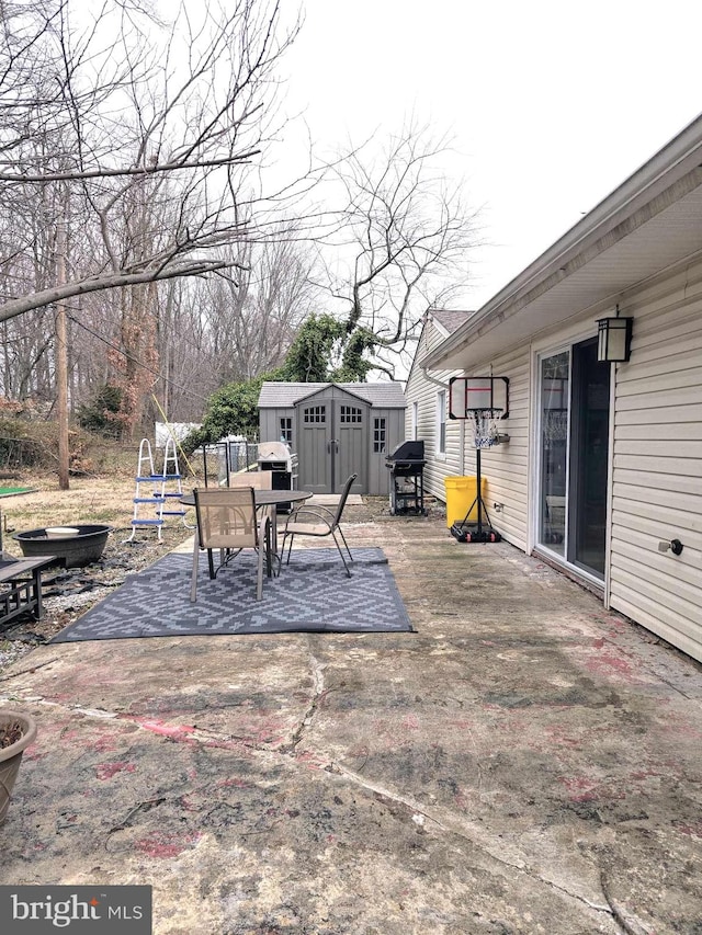 view of patio / terrace with a storage shed, outdoor dining area, an outdoor structure, and grilling area