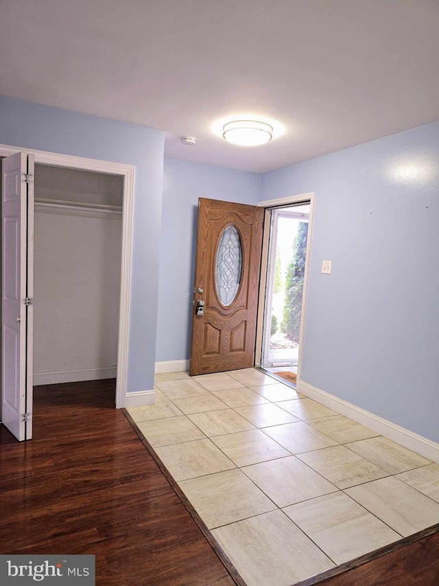 foyer with baseboards and light wood-type flooring