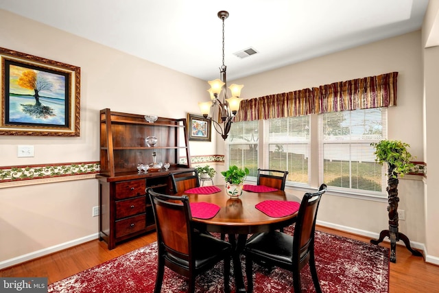 dining room featuring light wood-type flooring, visible vents, baseboards, and a chandelier