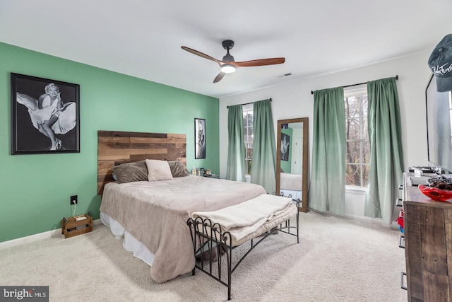 bedroom with visible vents, light colored carpet, baseboards, and ceiling fan