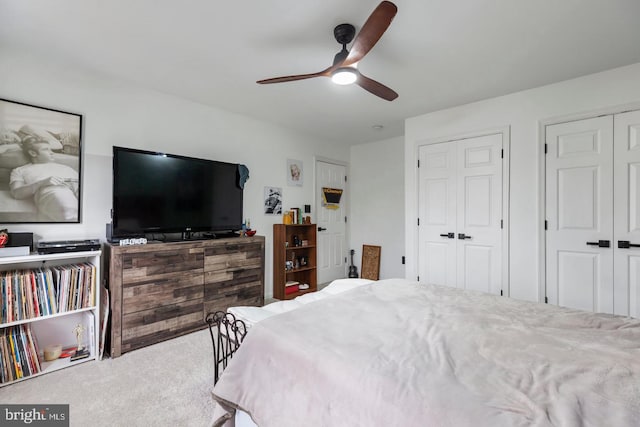 carpeted bedroom featuring a ceiling fan and multiple closets