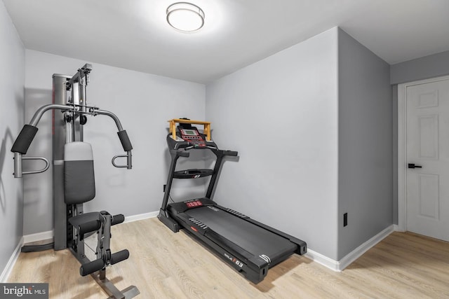 workout area with baseboards and wood finished floors