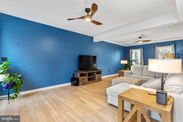 living area featuring beam ceiling, baseboards, ceiling fan, and wood finished floors