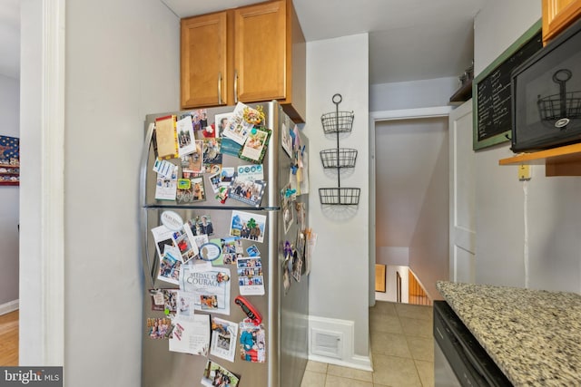 kitchen featuring light tile patterned floors, light stone countertops, visible vents, appliances with stainless steel finishes, and brown cabinets