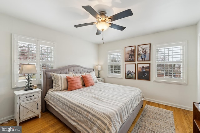 bedroom featuring a ceiling fan, light wood-type flooring, and baseboards