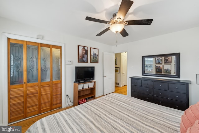 bedroom with ceiling fan, a closet, and wood finished floors