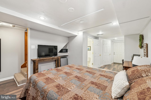 bedroom featuring recessed lighting, ensuite bathroom, and wood finished floors