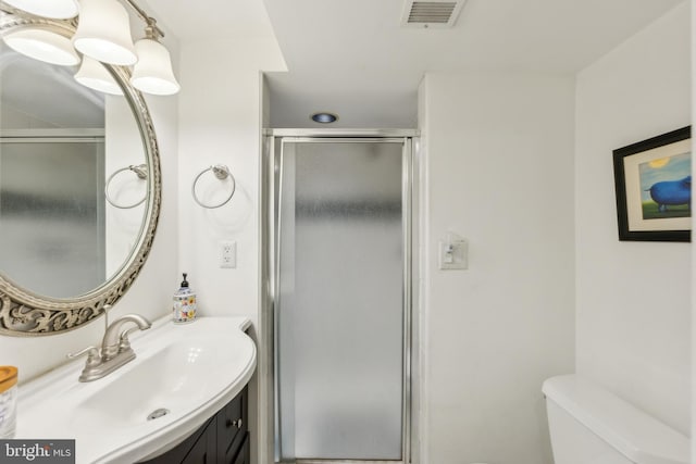 full bath featuring vanity, toilet, visible vents, and a stall shower