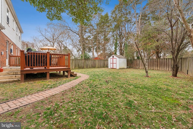 view of yard with a deck, an outbuilding, a fenced backyard, and a shed