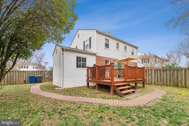 rear view of house with a yard, a deck, and a fenced backyard