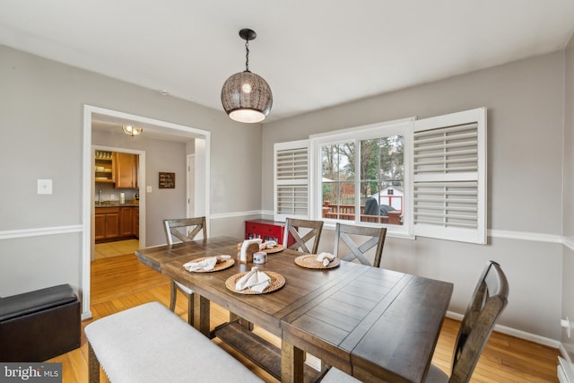 dining room with baseboards and light wood-style floors